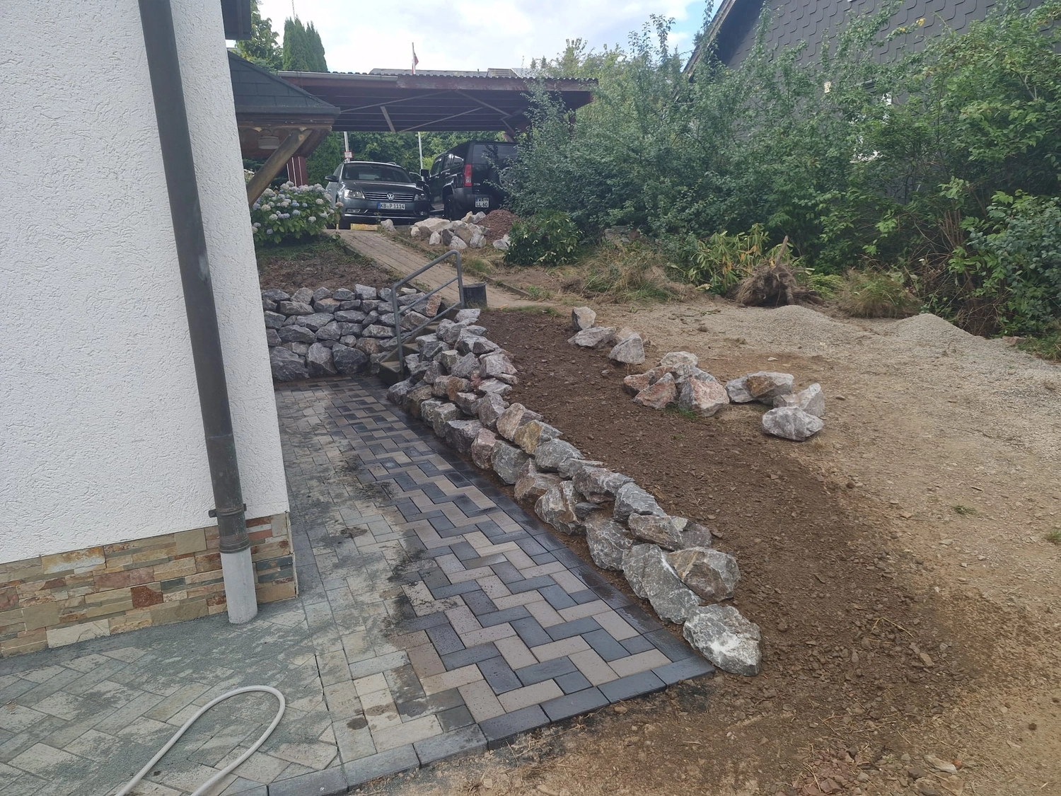 Natursteinmauer mit angrenzendem Pflasterweg